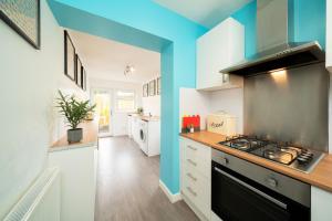 uma cozinha com um fogão e uma parede azul em Westland Shores em Crail