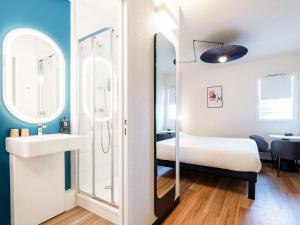 ペルピニャンにあるibis Perpignan Sud Saint Charlesのベッド、洗面台、鏡が備わる客室です。