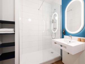y baño blanco con lavabo y ducha. en ibis Perpignan Sud Saint Charles, en Perpiñán