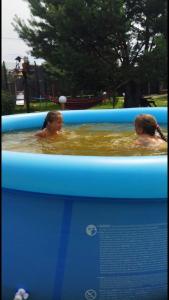 Dos niños están nadando en una piscina en un barco en Казковий Світязь, en Szack