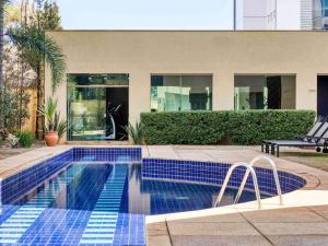 a swimming pool in front of a house at Caesar Business Belo Horizonte Belvedere in Belo Horizonte