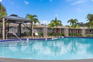 a large swimming pool with a gazebo at Super 8 by Wyndham Kissimmee-Orlando in Orlando