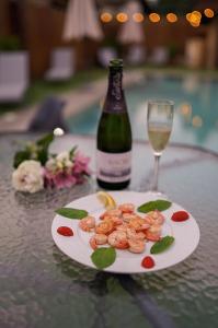 Guest house Wishmore في بانيا: طبق من الروبيان وزجاجة من النبيذ على الطاولة