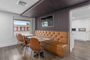 a dining room with a bench and a table and chairs at Super 8 by Wyndham Kissimmee-Orlando in Orlando