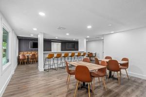 ein Esszimmer mit Tischen und Stühlen und einer Bar in der Unterkunft Super 8 by Wyndham Kissimmee-Orlando in Orlando + 76 Fotos