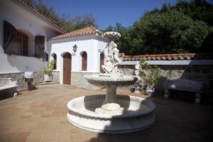 a fountain in a courtyard in front of a house at Hostal Mar de Frente in Los Caños de Meca