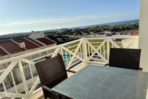 einen Tisch und Stühle auf einem Balkon mit Meerblick in der Unterkunft Best Houses 87 - Beachfront Duplex in Ferrel
