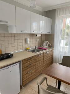 a kitchen with white cabinets and a table and a sink at FA&BER Homes in Marmaris