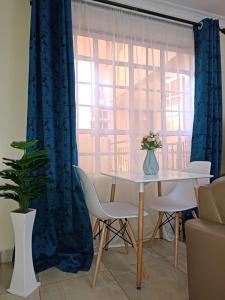 a dining room with a table and a window at Lux Suites Neema court Apartments in Nairobi
