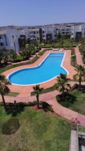 an overhead view of a swimming pool with palm trees at Résidence Perla appart 2 pièces in Saïdia