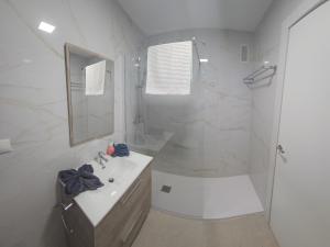 a white bathroom with a sink and a shower at Tao in Torremolinos