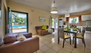 a kitchen and living room with a couch and a table at Villa Esperanza by Imagine Lefkada in Lefkada