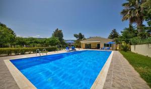 a large blue swimming pool in front of a house at Villa Esperanza by Imagine Lefkada in Lefkada Town