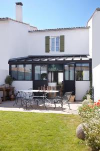 Maisons 322 - L'Insolite في لو بوا بلاج-أون-ري: فناء به طاولة وكراسي أمام المنزل