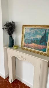 a white table with a painting and a vase on it at Loft apartment at Villa Leonie in Hyères