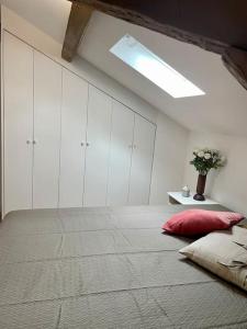 een slaapkamer met een groot bed met een rood kussen bij Loft apartment at Villa Leonie in Hyères +10 foto's