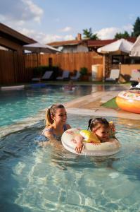 a woman and a child in a swimming pool at Guest house Wishmore in Banya