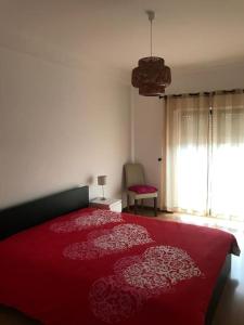 1 dormitorio con 1 cama roja y 2 almohadas rojas en T2 Ocean View House en Ericeira