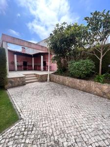 a house with a brick walkway in front of it at T2 Ocean View House in Ericeira