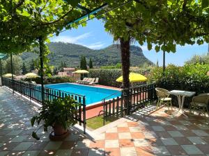 een zwembad met een tafel en stoelen bij Hotel Giotto in Garda