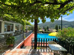 uitzicht op het zwembad vanaf de patio van een huis bij Hotel Giotto in Garda