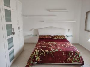 - une chambre avec un lit et une couette rouge dans l'établissement Villa Borraco - 800m from the SEA, à San Pietro in Bevagna