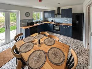 a kitchen with a wooden table with chairs in it at No, 1 Fox Burrow-uk44306 in Lenwade