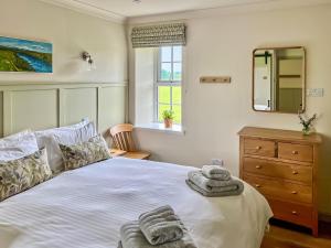 a bedroom with a bed with towels on it at Kingfisher Cottage in Kirkton of Airlie