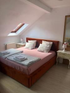 a bedroom with a bed with pink sheets and white pillows at Viking in Dziwnów