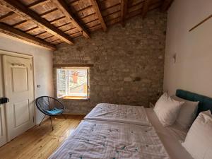 een slaapkamer met een bed, een stoel en een raam bij Apartment Luka in Rovinj