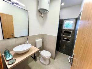 a bathroom with a sink and a toilet and a mirror at Fantažija Apartment in Brodarica