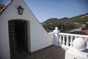 a white house with a door and a balcony at Hostal Mar de Frente in Los Caños de Meca