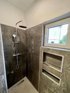 a bathroom with a shower and a window in it at Fantažija Apartment in Brodarica