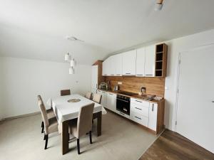a kitchen with a white table and chairs in a room at Ilidža Park Apartments in Sarajevo