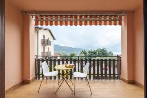 d'un balcon avec une table, des chaises et une grande fenêtre. dans l'établissement Loreto Sunset, à Marone