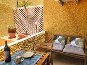 a table and chairs and a couch on a balcony at Nena Luxury Home by HelloApartments in Puerto de Santiago