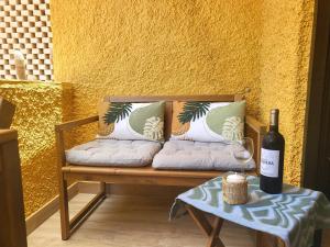 a bench with a bottle of wine and a table at Nena Luxury Home by HelloApartments in Puerto de Santiago