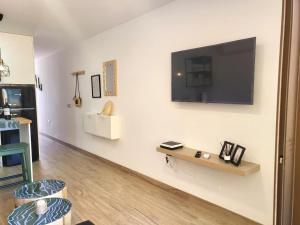a living room with a flat screen tv on a wall at Nena Luxury Home by HelloApartments in Puerto de Santiago