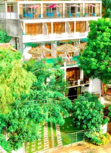 a tall building with trees in front of it at Mirissa Beach Inn in Mirissa