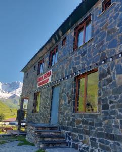 um edifício de pedra com um sinal na lateral em Hotel Tekla em Ushguli