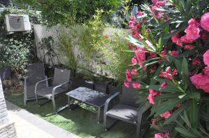 d'un jardin avec des chaises et des fleurs. dans l'établissement SKYLINE Apartments, à Cap d'Ail