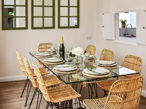 een eetkamer met een glazen tafel en stoelen bij Pebble Cottage in Middleton-on-Sea