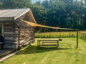 una panchina da picnic di fronte a una baita di tronchi di The Sunset Cabin a Beccles