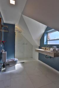 an attic bathroom with a toilet and a sink at Ti Voglio Bene in Campos do Jordão