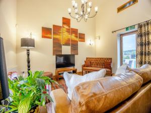 a living room with a leather couch and a television at The Granary - Uk44520 in North Thoresby