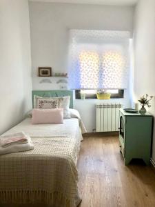 a small bedroom with a bed and a window at SANTA LUCÍA Garaje privado in Zamora