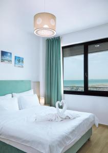 um quarto com uma cama e uma grande janela em Excelsior apartaments 2 mamaia nord em Mamaia Nord – Năvodari