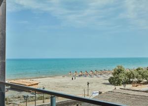 uma vista para uma praia com guarda-sóis e para o oceano em Excelsior apartaments 2 mamaia nord em Mamaia Nord – Năvodari