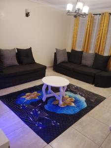 a living room with a table and a couch at Lux Suites Neema Court Furnished Apartments in Nairobi