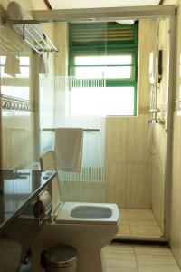 e bagno con servizi igienici, lavandino e doccia. di Highlands Suites Hotel and Apartments a Kigali